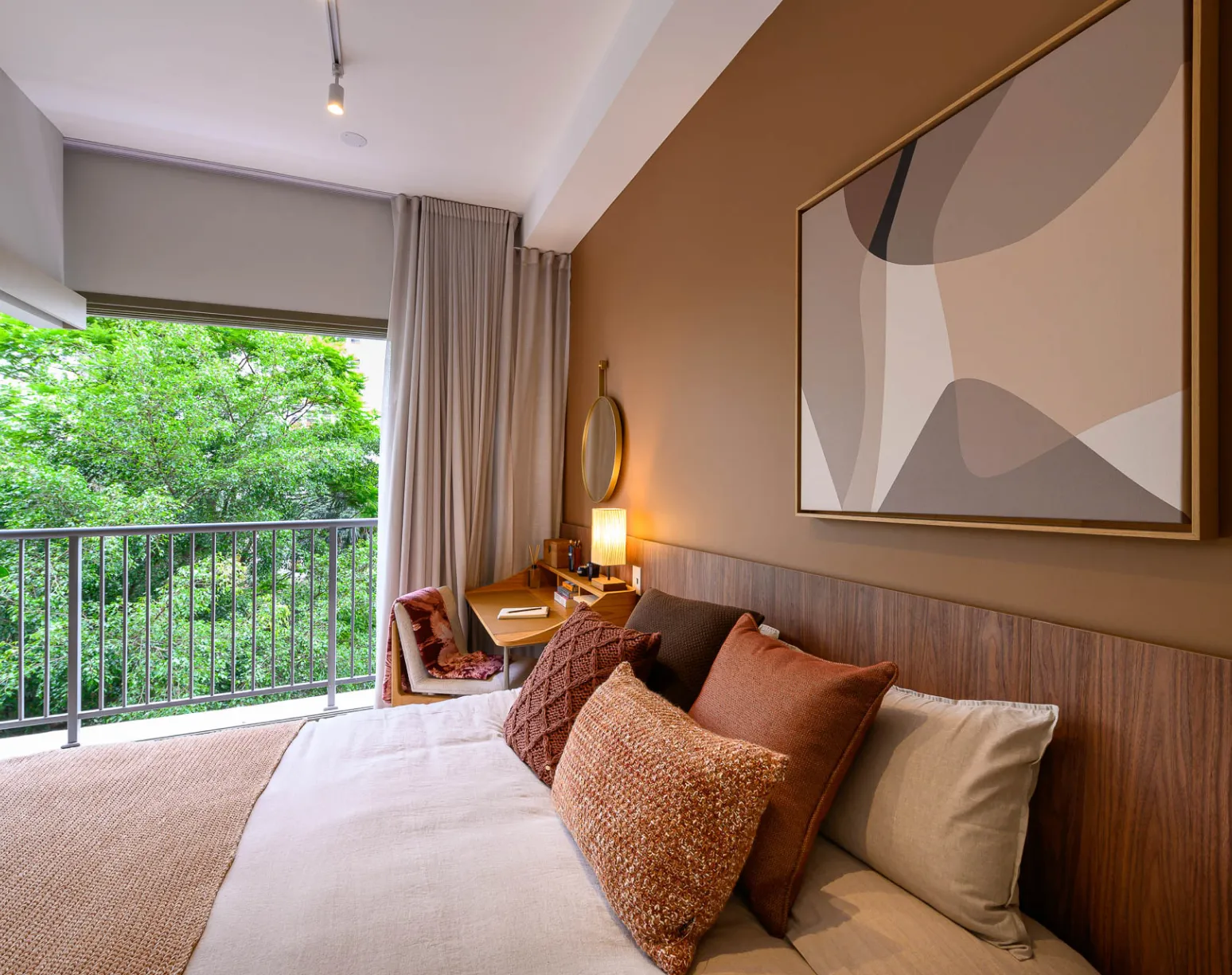 Modern bedroom with a sophisticated design. Double bed with light bedding, padded headboard, and decorative pillows. Background wall featuring mirrors with organic shapes and built-in lighting. Wardrobe with mirrored doors on the side, reflecting the elegant setting.